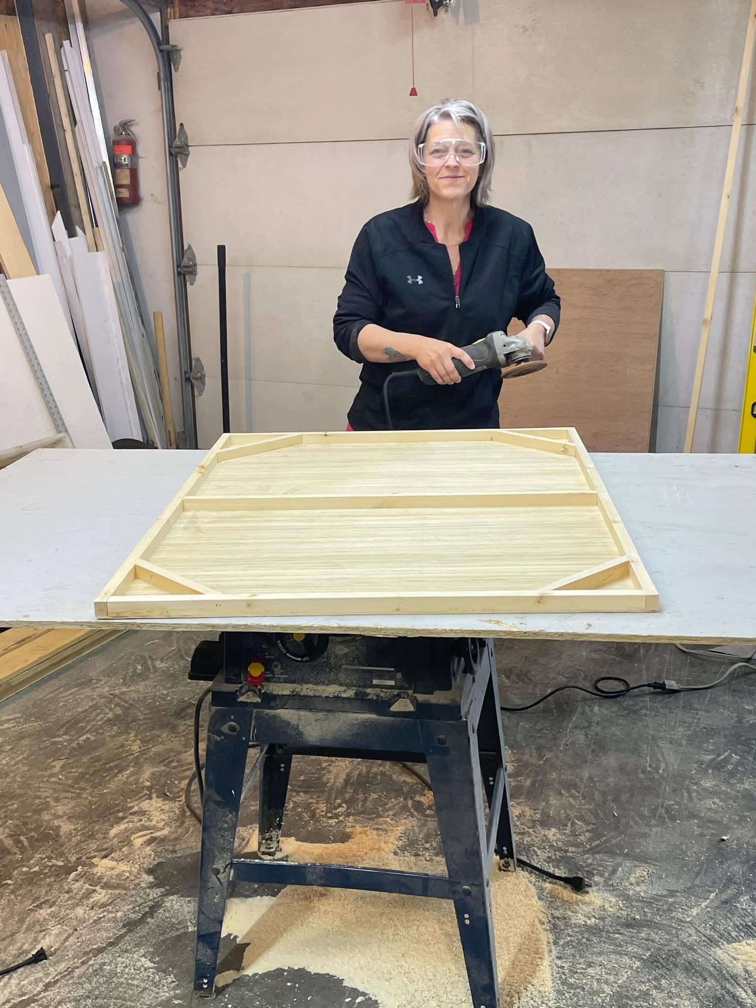 Karine ponçant un plateau de bois à l'atelier